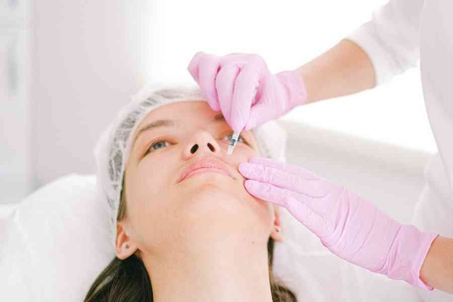 Косметолог делает девушке инъекции в лицо