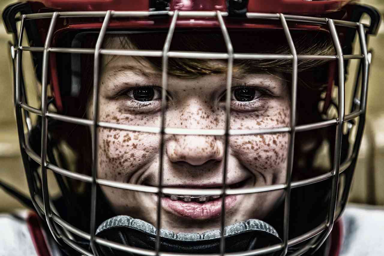 Мальчик в хоккейной каске и брекетах