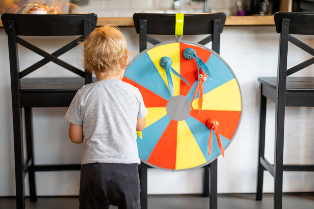 Один ребенок играет в дротики дома