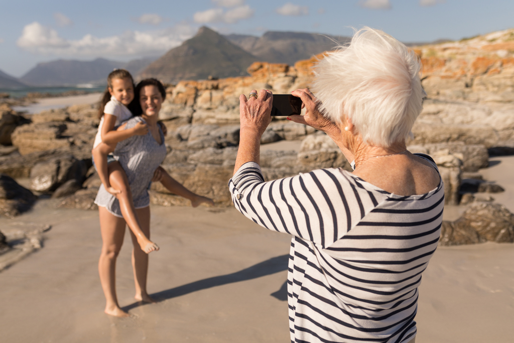 Женщина снимает на фотоаппарат свою дочку и внучку
