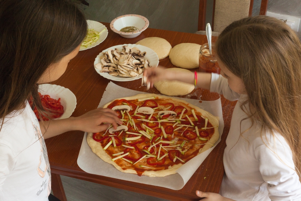 Мама и дочка готовят домашнюю пиццу