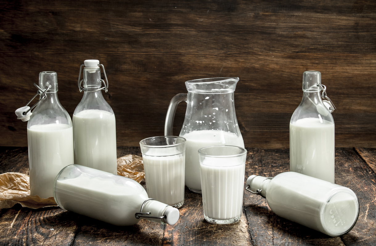 Две бутылочки молока на фоне коров