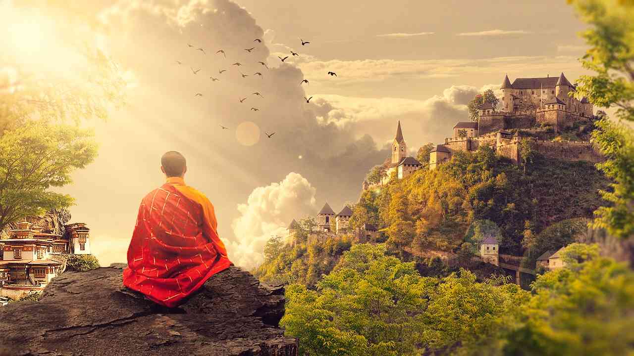 Азиатский монах медитирует в горах с видом на храмы и дома