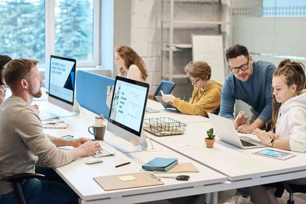Люди в офисе сидят за компьютерами