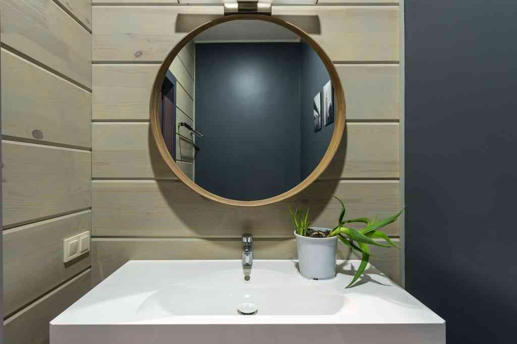 Декоративные панели под дерево в ванной возле раковины и зеркала