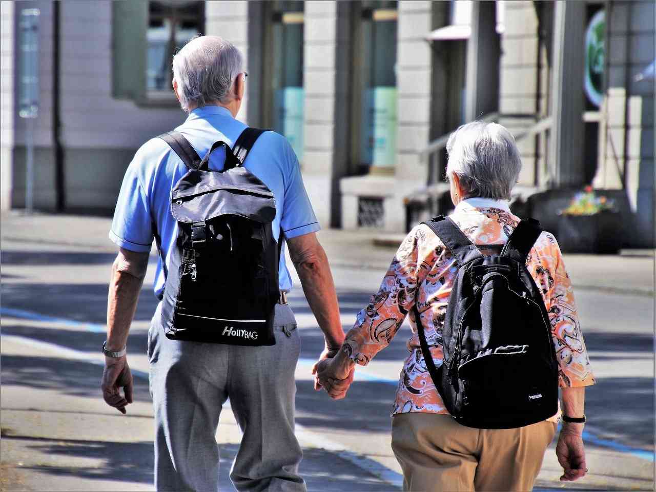 Два пенсионера идут по улице, держась за руки