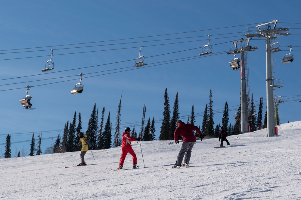 Инструктор обучает новичка катанию на горных лыжах в Шерегеше