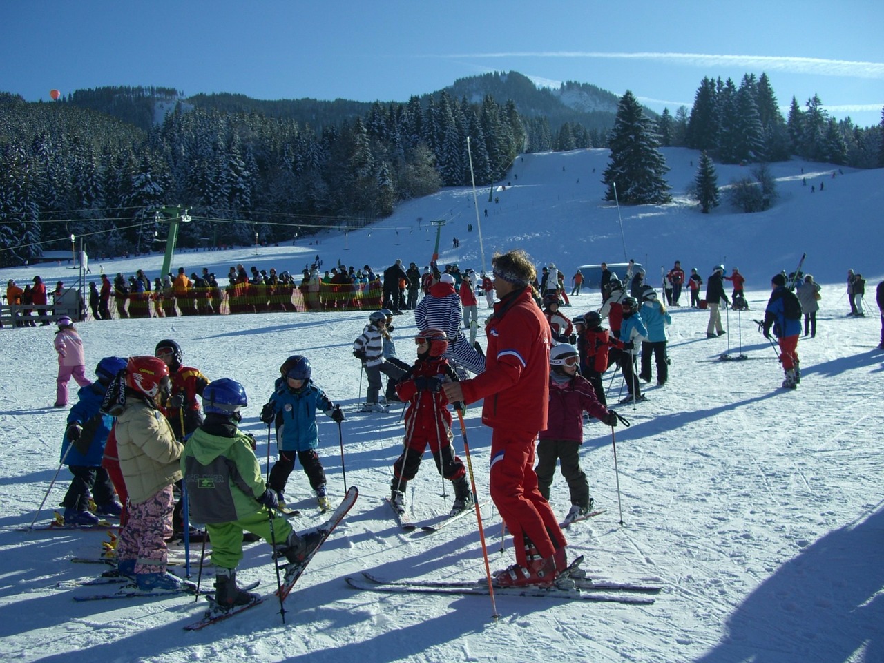 Инструктор проводит урок катания на лыжах с группой детей