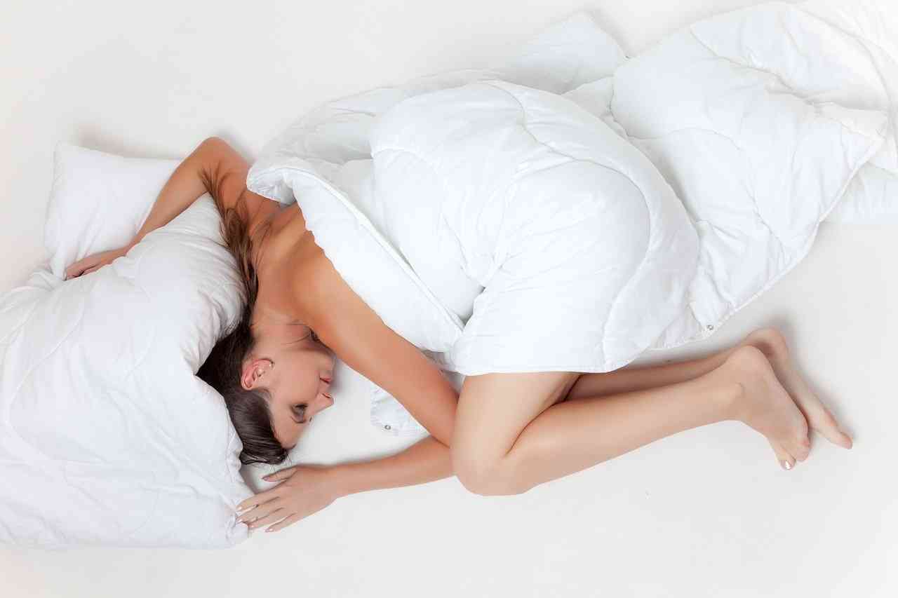 Женщина спит на боку в позе полукруга