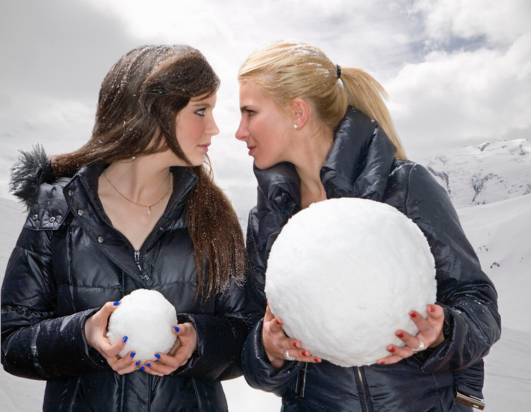 Женщины держат в руках маленький и большой снежные шары