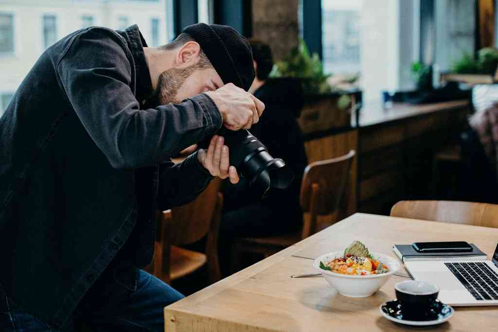 Мужчина фотографирует еду на столе